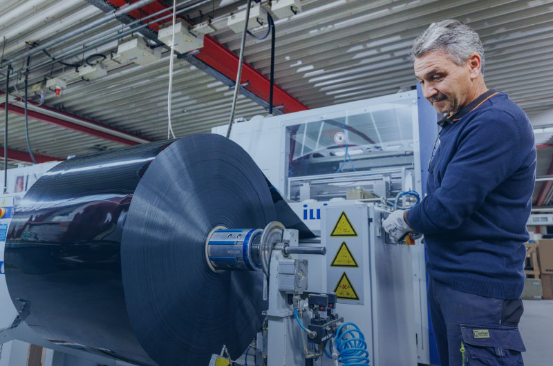 Person legt Rohware in Maschine ein